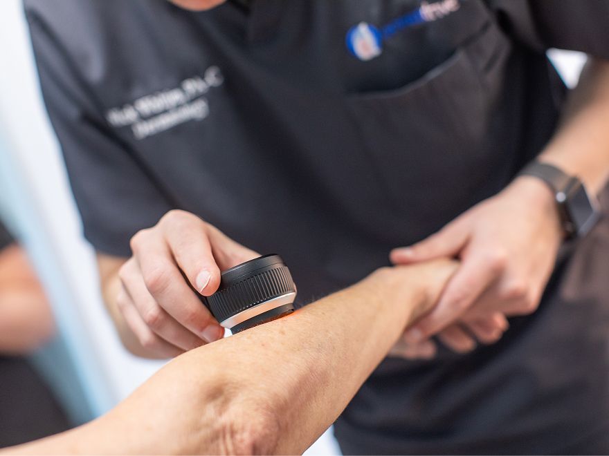 Healthcare professional examining a patient's arm.