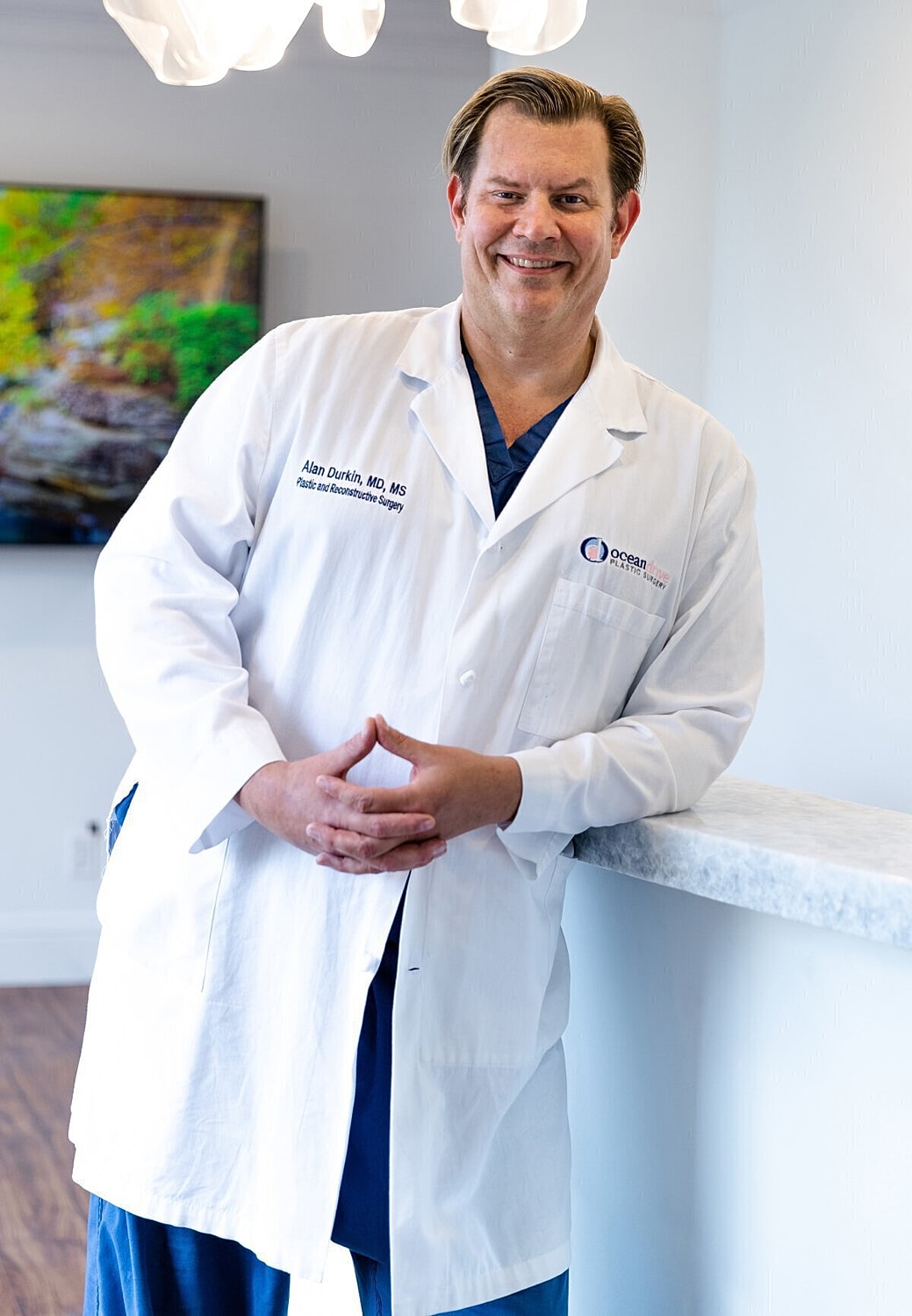 Doctor in a lab coat smiling at camera.