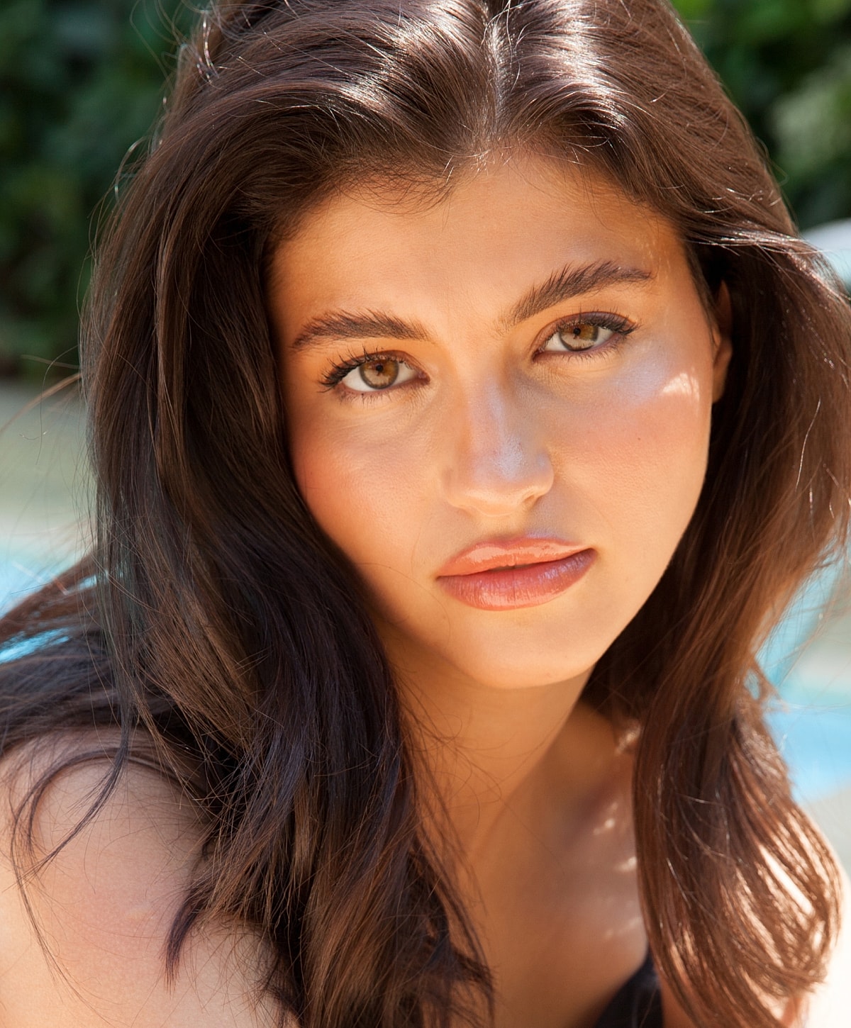 Smiling woman with wavy hair outdoors.