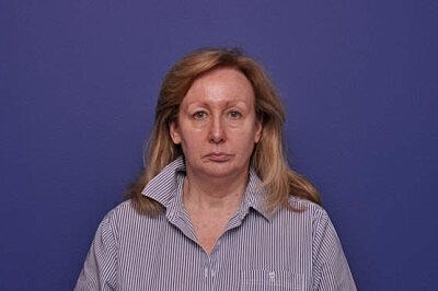 Woman with long hair against purple background.