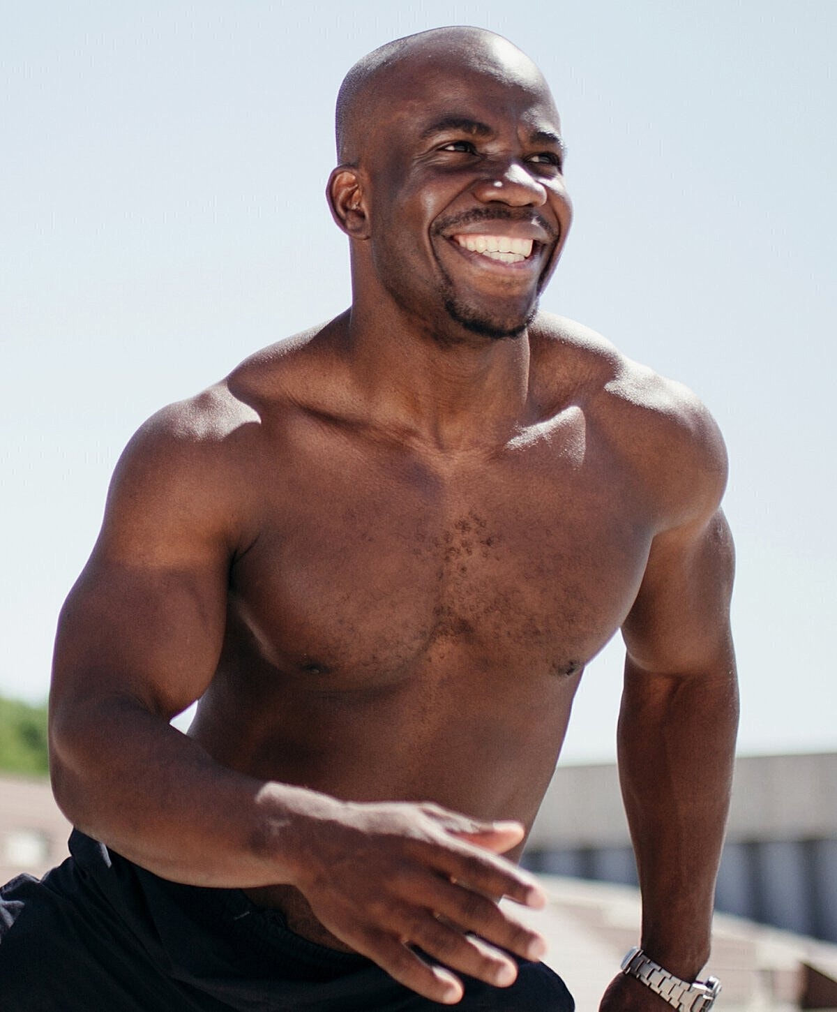 Smiling man in blue shirt against light background.