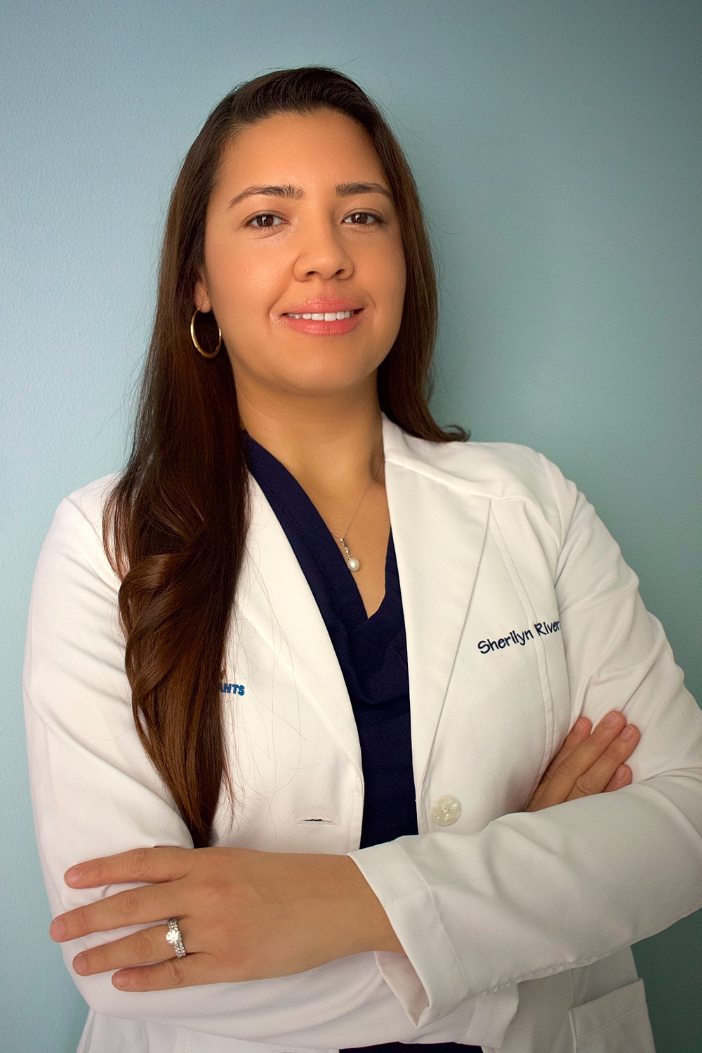Smiling man in blue suit against plain background.
