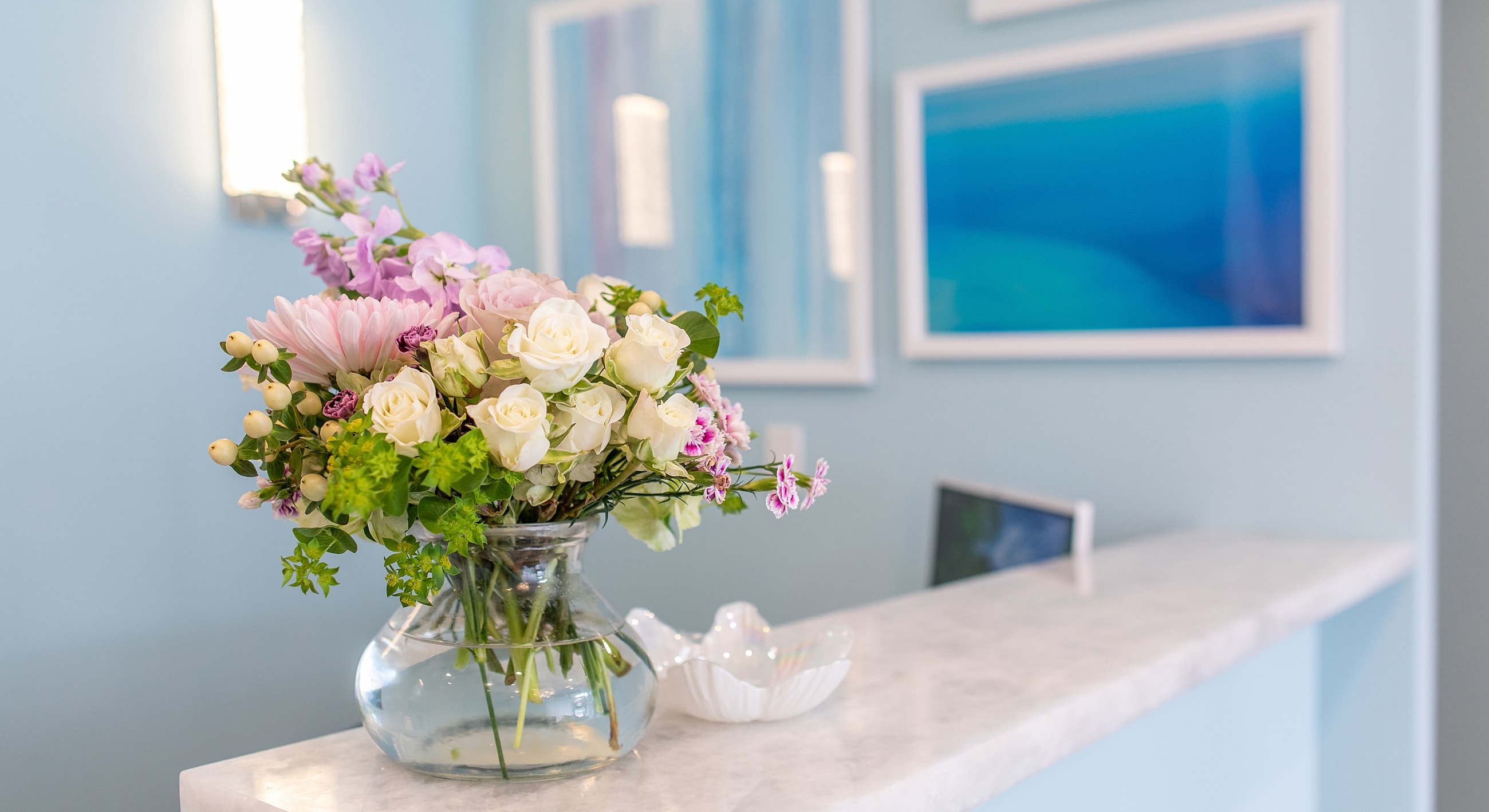 Vase of mixed flowers on a light countertop.