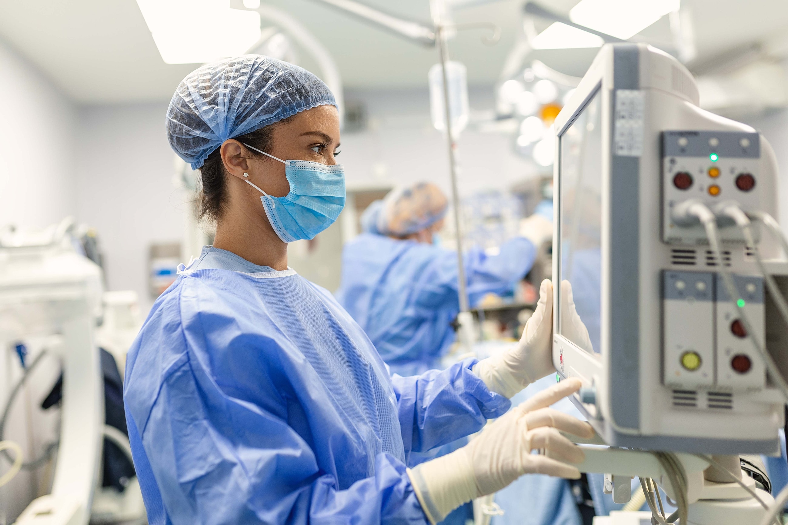 Medical professional monitoring equipment in surgery.