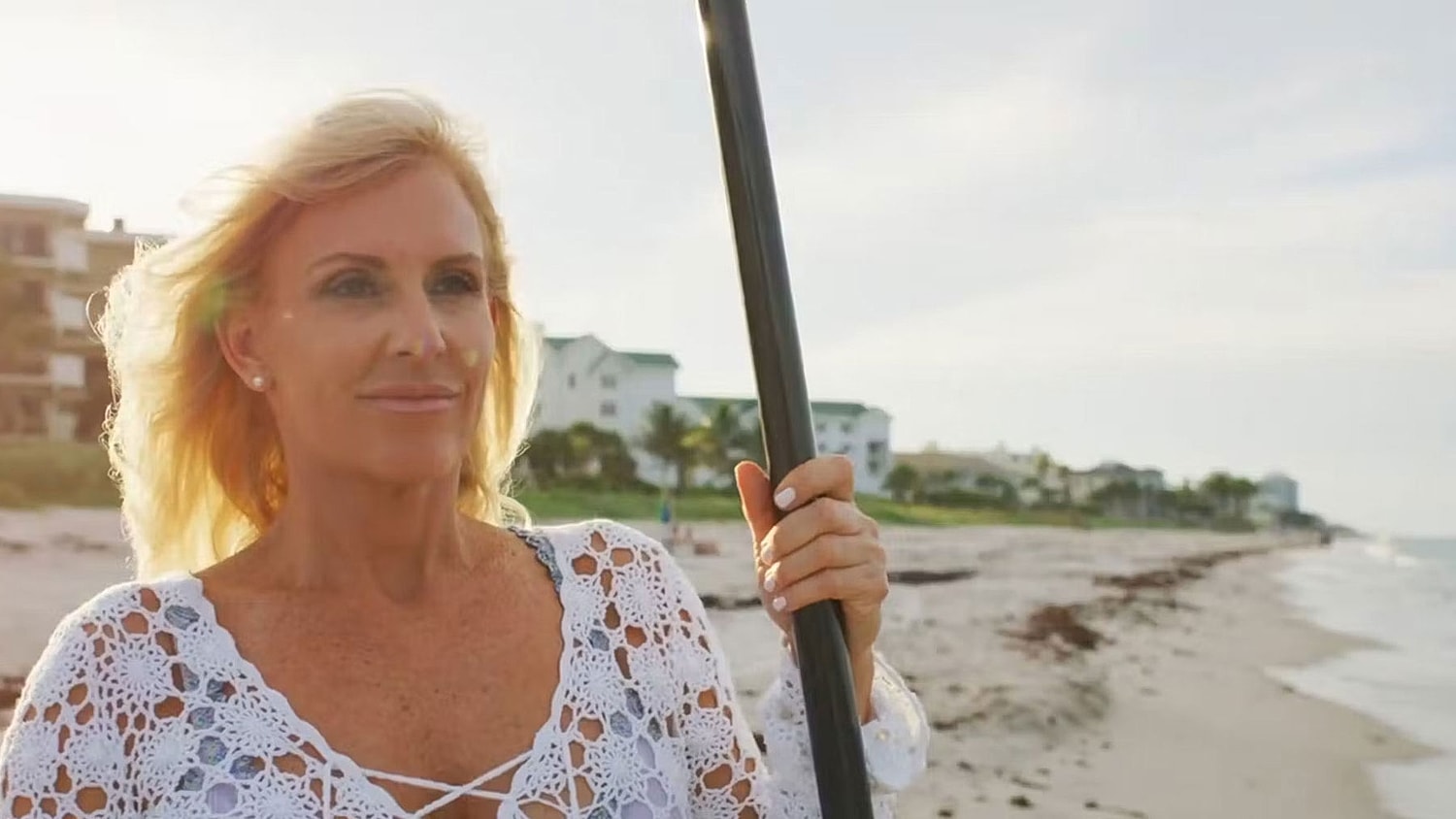 Woman in bikini walking along the beach.