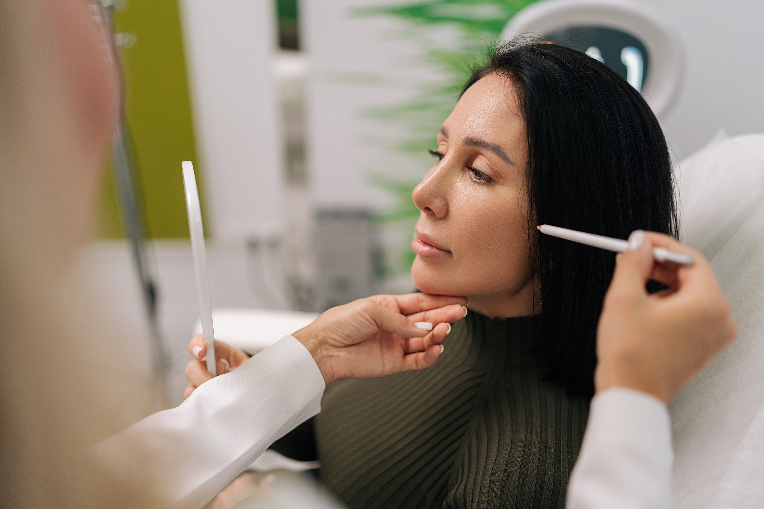 Woman consulting beauty expert in clinic setting.