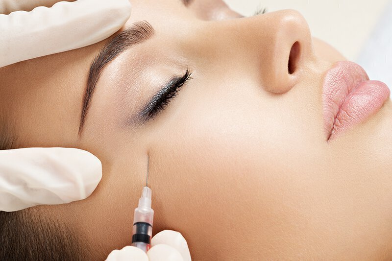 Woman with injection being put in face