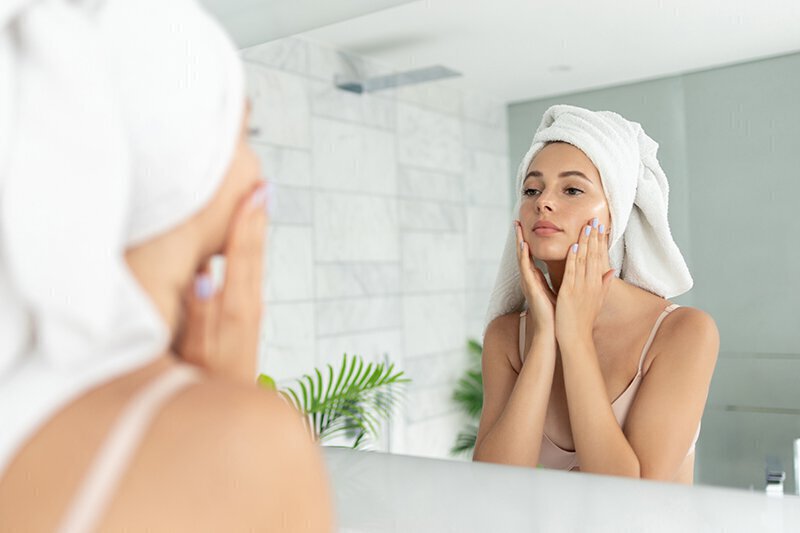 Woman in mirror with white towel