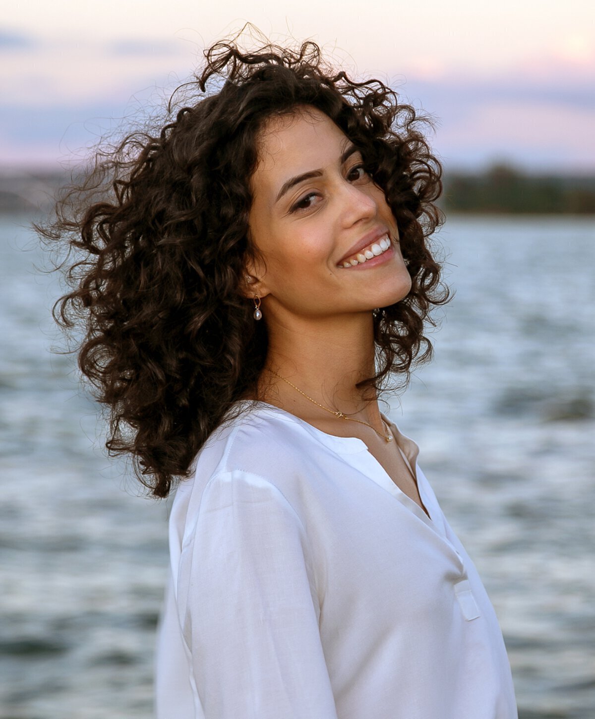 Woman with black curly hair smiling