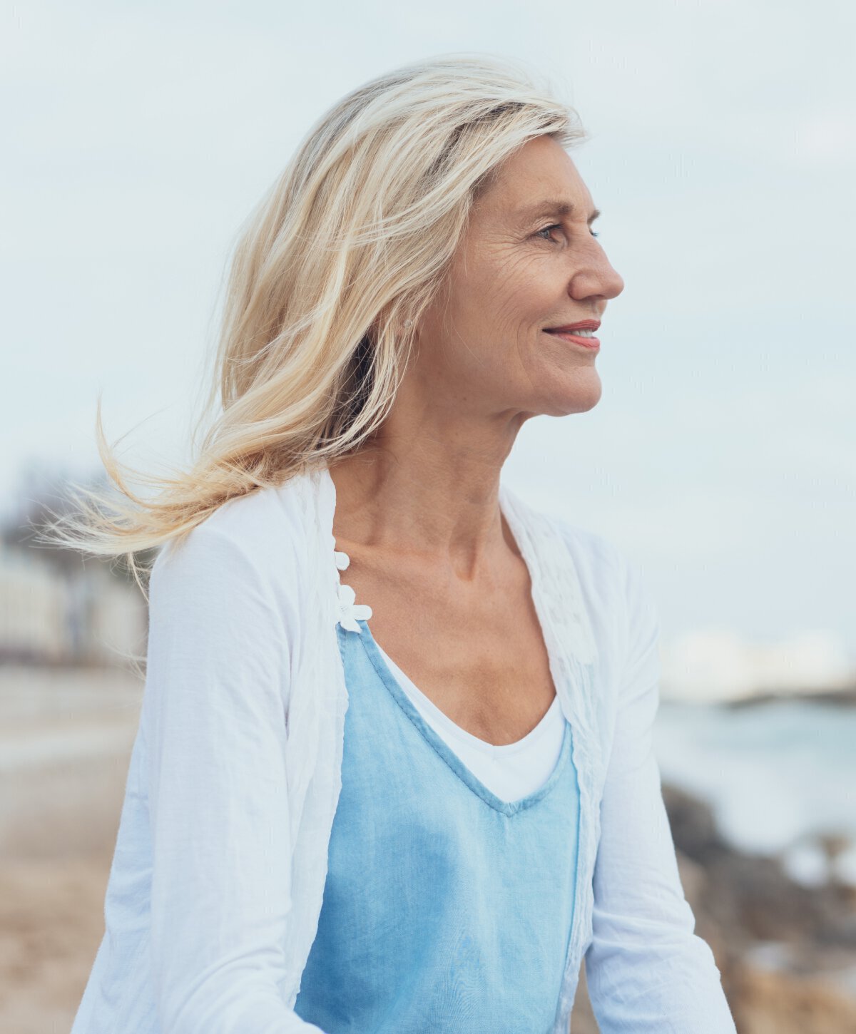 Blonde woman smiling with white and blue top