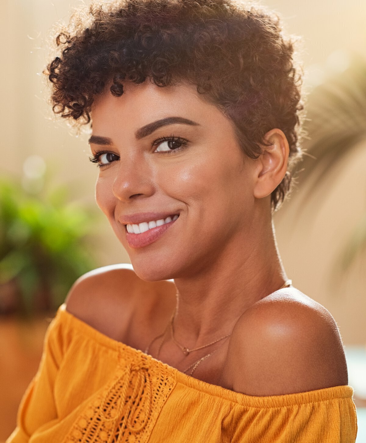 Dark haired woman with orange top smiling