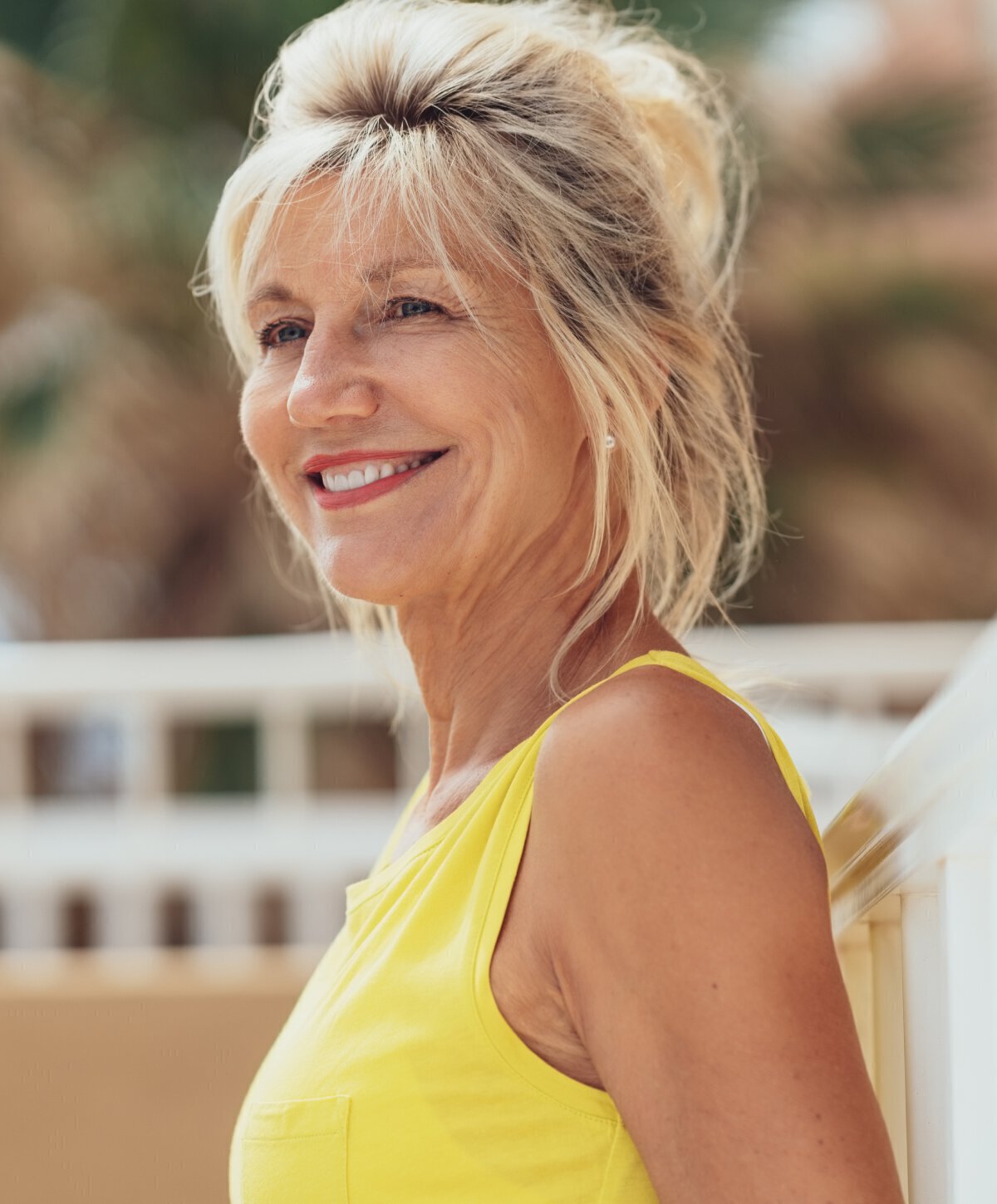 Woman with yellow top after eyelid surgery