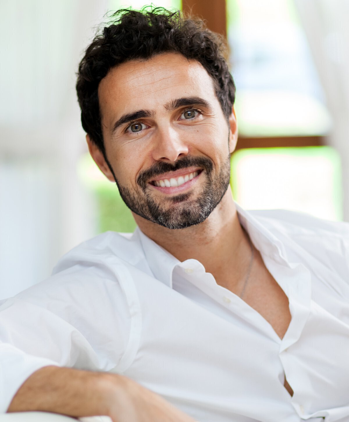Man in white shirt sitting and smiling