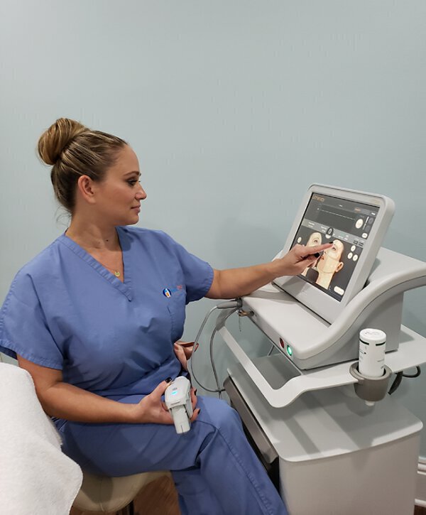 Woman using ultherapy machine for skin treatment
