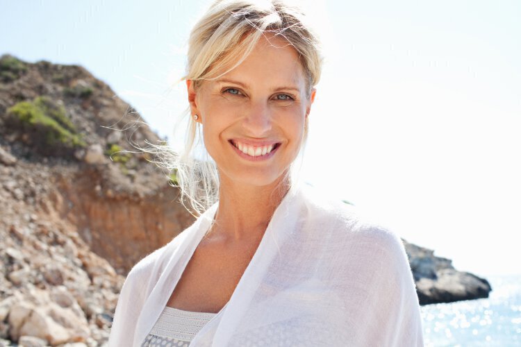 Collagen Induction feature - Blonde woman smiling on beach