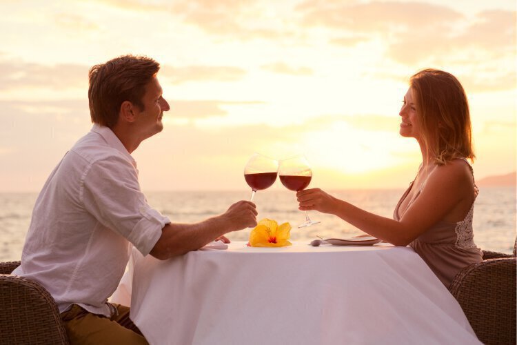 Couple having romantic dinner clinking wine glasses